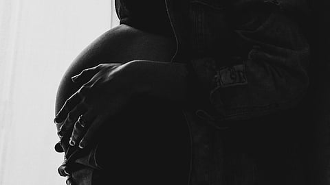 An image of a pregnanat lady holding her belly.