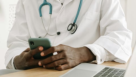 An image of a doctor using his mobile.