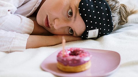 An iamge of a girl staring at a donut.