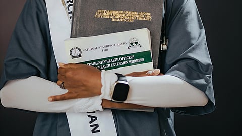 An image of a student holding medical degree.