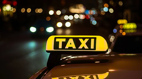 A photo of a board of Taxi driver on the car. 