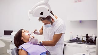 Dentist examining female patient teeth.