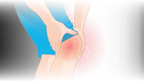 A person holding his knees, which imparts a feeling of pain.