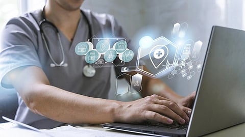 A doctor is working in his laptop from which holograms of different structures is appearing. 