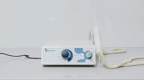 An image of a white medical device with a blue knob and buttons.