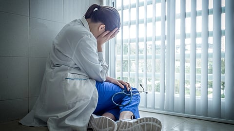 Female Doctor sitting on ground and crying