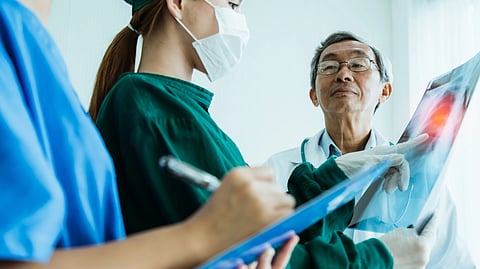 Chinese doctor and nursing team examine x22ray film of patient analysis to find best solution for operation and treat health ideas concept