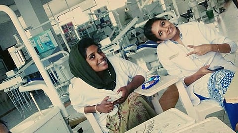 Two dental students sitting in a clinical posting in a college. 
