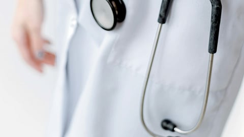 Close-up of a doctor wearing a white coat and stethoscope.