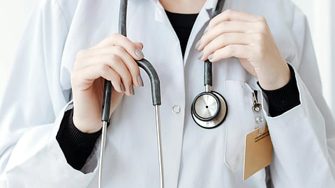 a close up of doctor wearing a stethoscope a white coat and a black t -shirt.