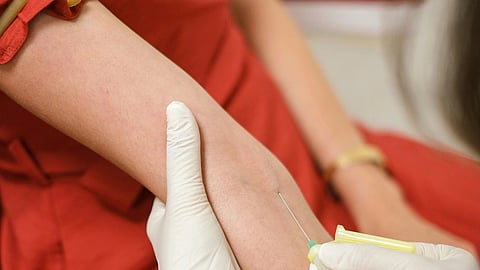 A nurse administering a blood transfusion to a woman in a hospital setting.
