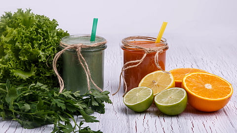 Two jars of smoothies with straws are on a table. 