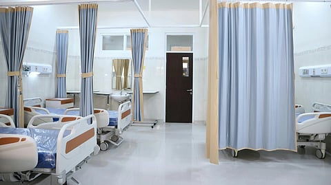 Hospital beds lined in a room.
