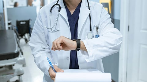 a doctor walking holding a writing pad and pen.