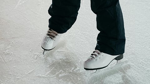 A man Ice skating in ice rink.