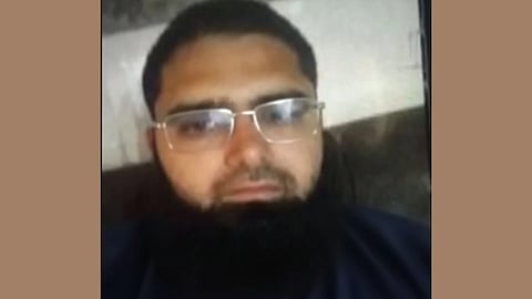 portrait of  Dr. Muzaffar Ahmad Rather wearing a navy blue t-shirt and spectacles.