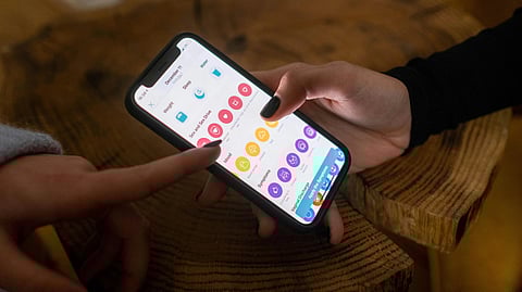 A person holding a mobile screen with mental health app on it.
