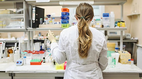 The back of a scientist and her working in a lab.