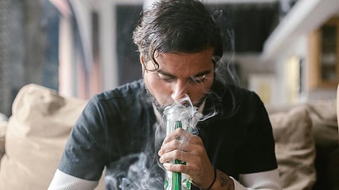 A person doing drugs with a bong.