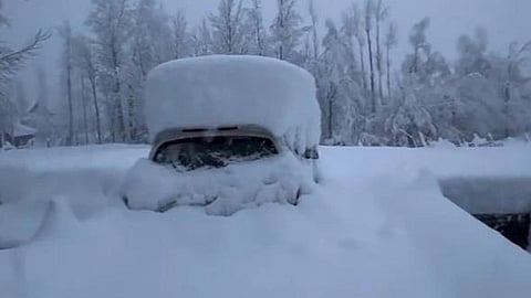 A vehicle stuck on a road due to heavy snow.