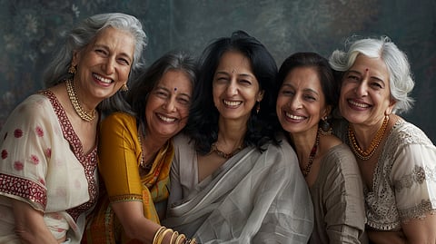 A group of old Indian women smiling and posing for the picture.