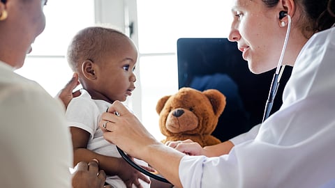 A doctor listens to a baby's heartbeat with a stethoscope. 