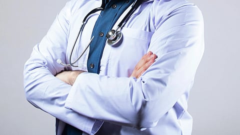 A doctor in white coat and stethoscope around neck.