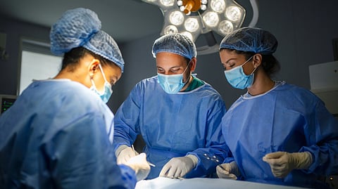 A team of surgeons performing surgery in an operation theatre.