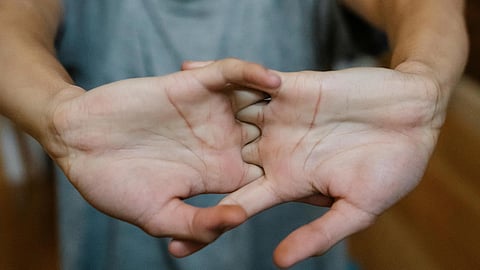 Young person stretches their fingers outward.