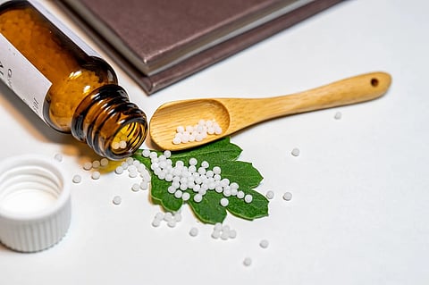 Homeopathic medicines stored in a glass bottle prepared from plant sources.
