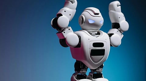 A humanoid robot with glowing blue eyes raises its arms in front of a blue background.