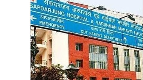 A big name board of Safdarjung hospital and the hospital building.   