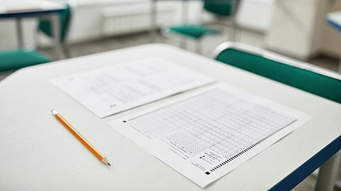 An examination paper kept on desk along with pencil.