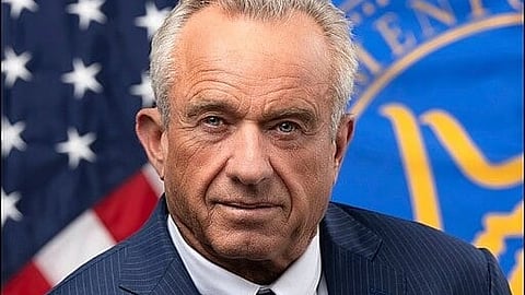 Close-up portrait of U.S. Health and Human Services Secretary Robert F. Kennedy Jr. wearing a blue striped coat, white shirt, and tie.