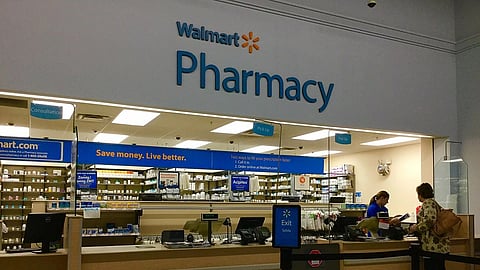 A Walmart pharmacy seen with medicines arranged in stacks on shelves.