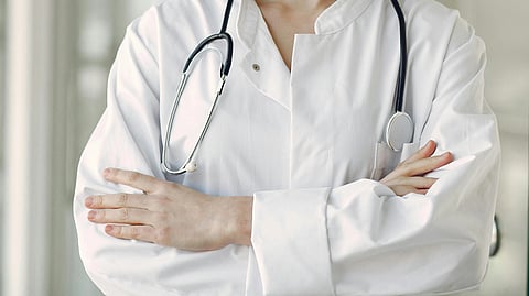 Close-up of a healthcare professional wearing a white coat and a stethoscope.