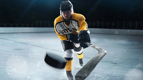 A hockey player in a yellow and black jersey on ice.