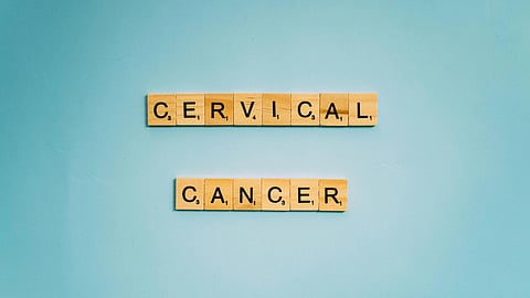 Wooden Scrabble tiles on a light blue background spell "Cervical Cancer" in two rows.