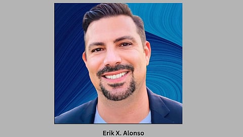 Dr. Erik in blue coat with grey background.