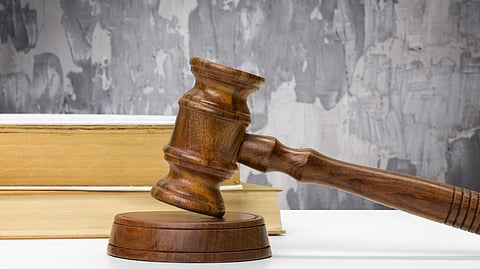 Wooden gavel and books on white surface.