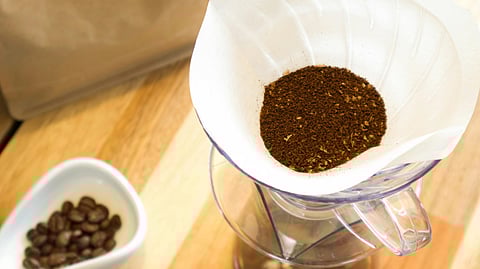 Close-up of a coffee on a filter paper over a glass jar.