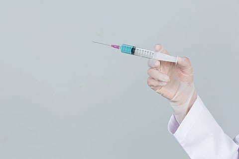 A doctor holding an injection. 