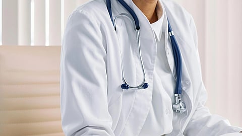 A doctor in a white coat and stethoscope around neck.