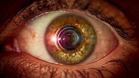 Eye with a camera lens and lens flare in the pupil