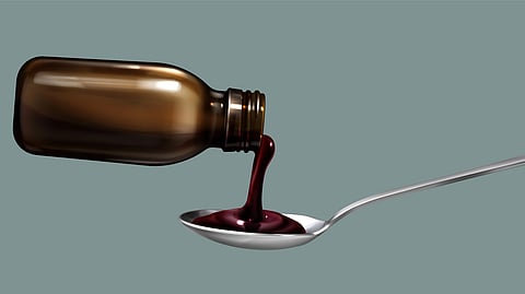 Brown bottle pouring thick, dark syrup into a spoon.