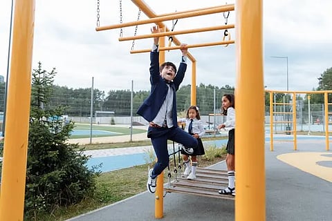 Children playing by hanging on the bars in a playground. 