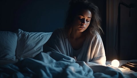 A woman looking groggy in the bed. 
