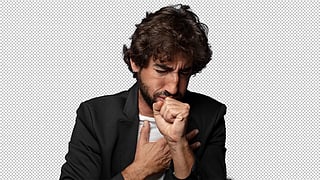 Bearded man in black jacket coughing, covering his mouth.