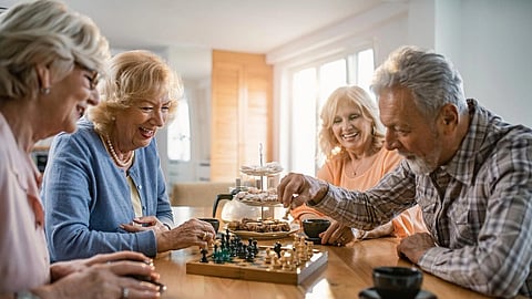 A community living centre for senior people, 3 women and 1 man seen playing chess. 