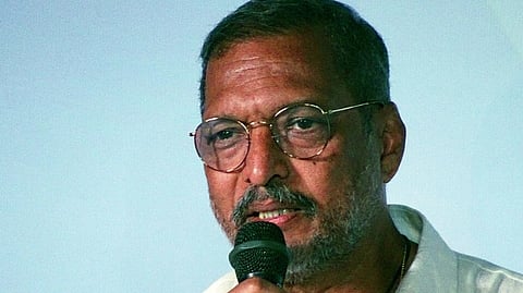 Nana Patekar wearing glasses and using mic.